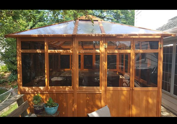 a hot tub enclosure with a transparent roof in the yard