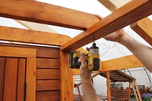 20. Attach the porch rafter bar to the top porch rails with screws.