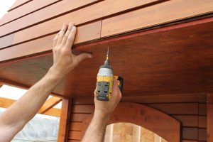 21. Attach the porch ceiling plywood sheet to the rafter bars and front gable with screws.