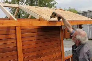 25. Attach roof plywood sheets on the roof and attach them to the rafters with screws. Do the same on the other side of the roof.