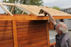 25. Attach roof plywood sheets on the roof and attach them to the rafters with screws. Do the same on the other side of the roof.