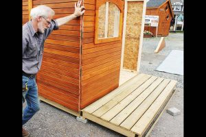 9. Align the front window wall in an upright position on the floor frame. And secure it with screws on the floor platform.